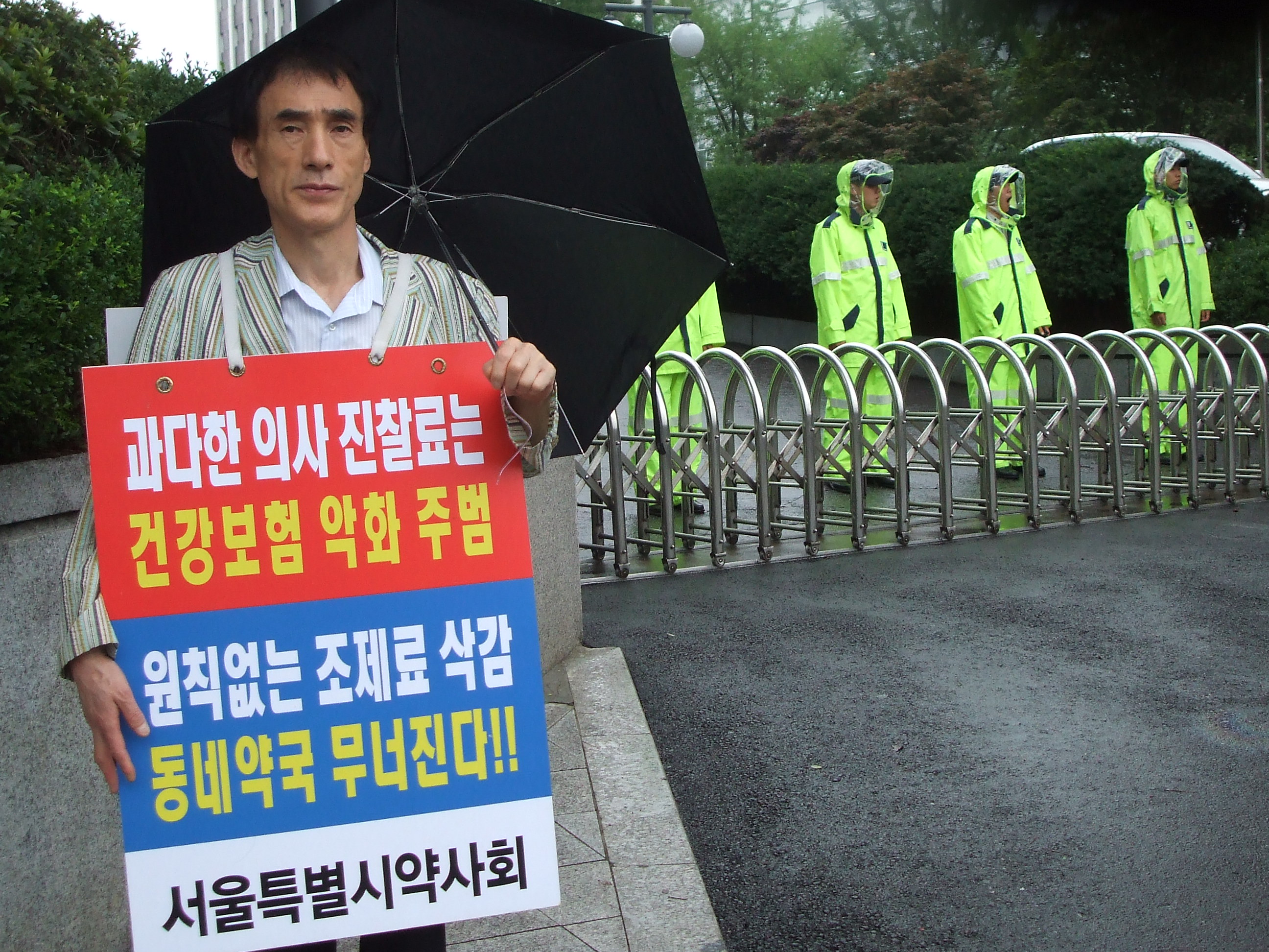 서울시약사회 한 회원이 13일 보건복지부 앞에서 '과다한 의사 진찰료는 건강보험 악화 주범', '원칙없는 조제료 삭감 동네약국 무너진다'는 메시지로 1일 시위를 하고 있다.