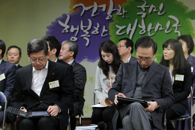 이명박 대통령(오른쪽)이 지난 23일 오전 서울 종로구 계동 현대빌딩 보건복지부 청사에서 태블릿PC를 이용해 임채민 장관의 2012년 보건복지부 업무보고를 모니터링하고 있다.<사진 왼쪽은 김황식 국무총리.>