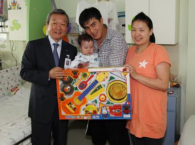 정희원 서울대병원장이 오차르밧 환아에게 위로의 선물을 전해주며 부모들과 함께 사진을 촬영하고 있다.